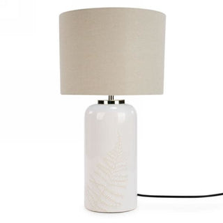 Lampe de table ivoire et beige avec motif de feuillage sur la base.