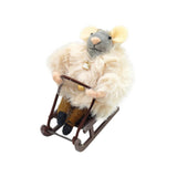 Souris décorative en laine (rose/blanc, 10 cm) sur une luge, vêtue d'un manteau de fourrure.
